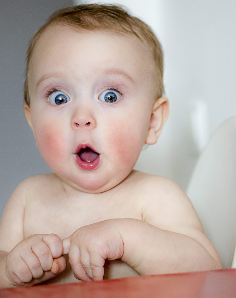 surprised kid sitting at table