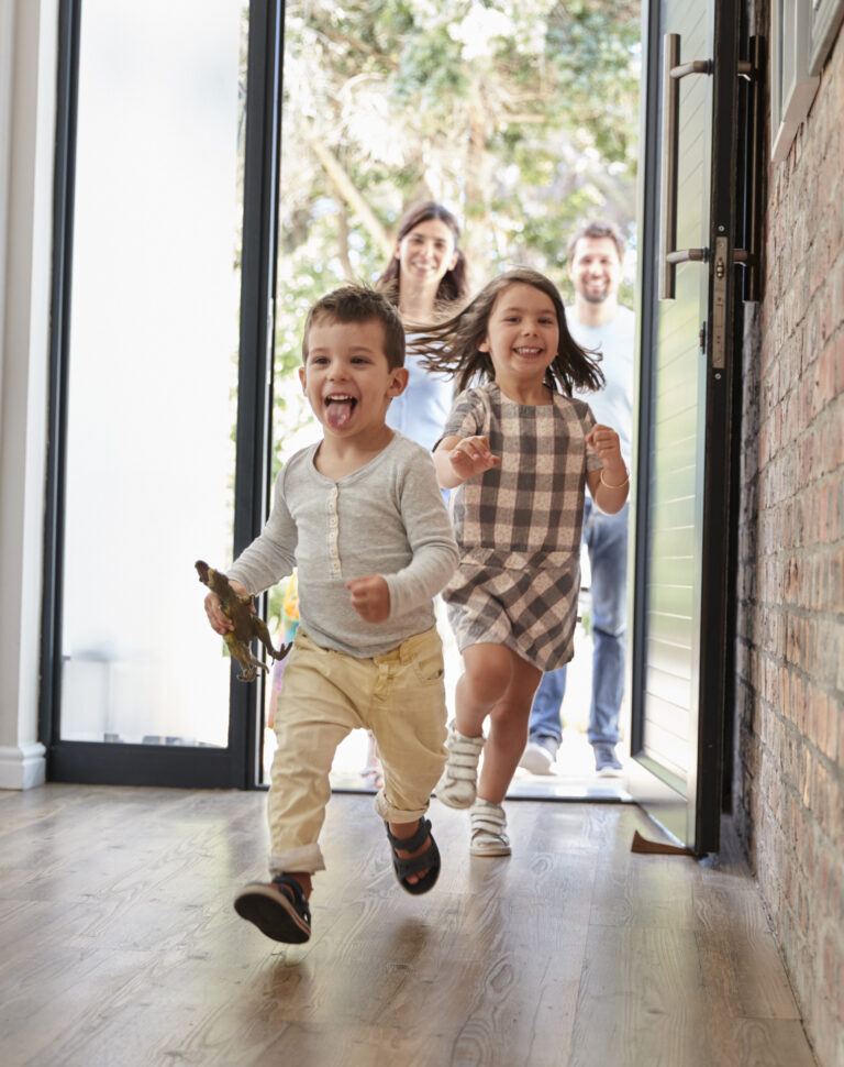 Excited Children Arriving Home With Parents