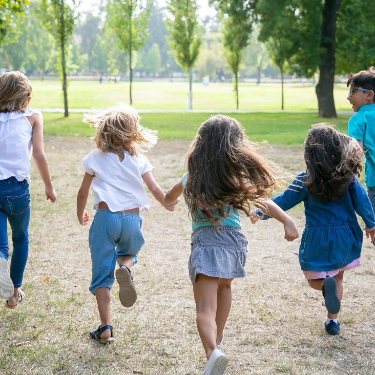Group of kids running on grass together