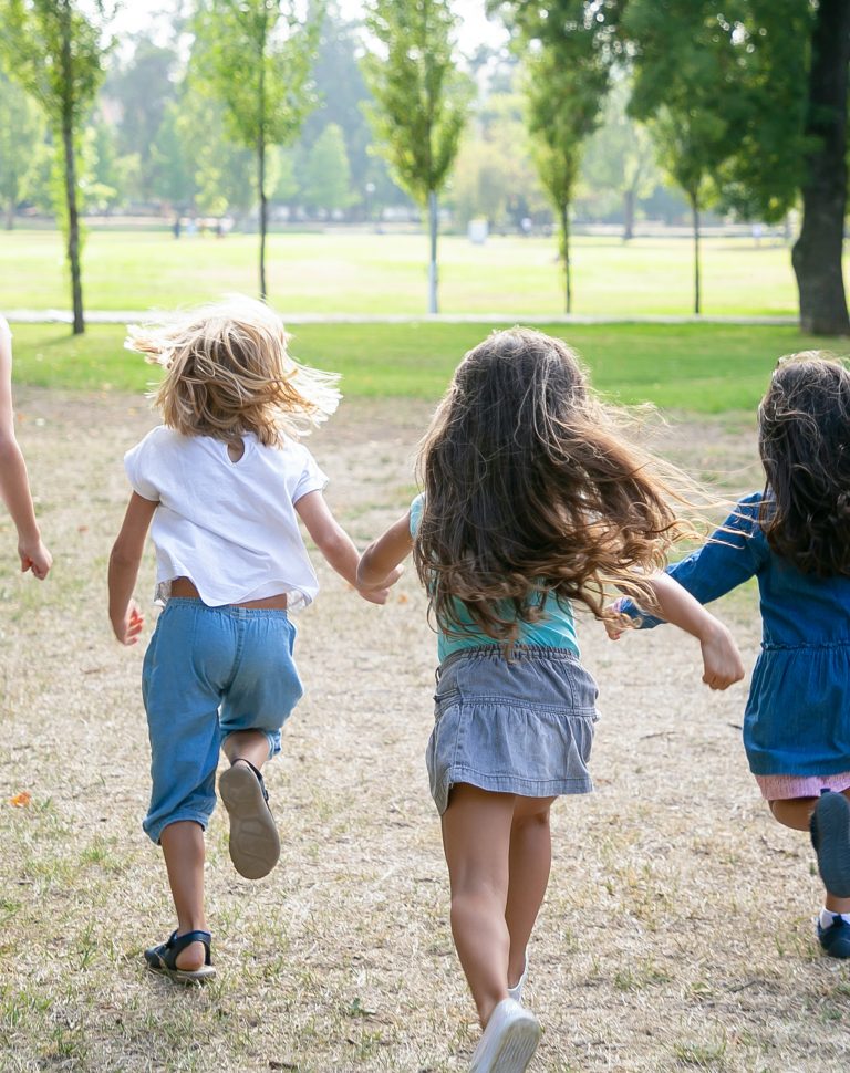 Group of kids running on grass together